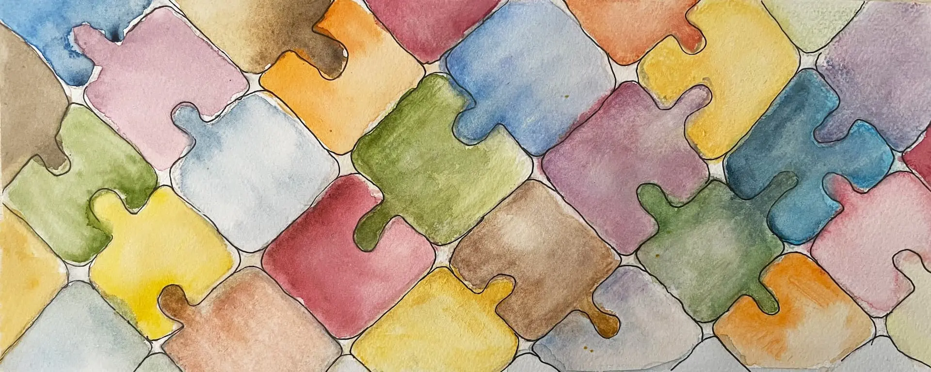 Bunt gemalte Puzzleteile in Aquarellfarben als Symbol für Vielfalt, Gemeinschaft und das Zusammenfügen von Teilen.